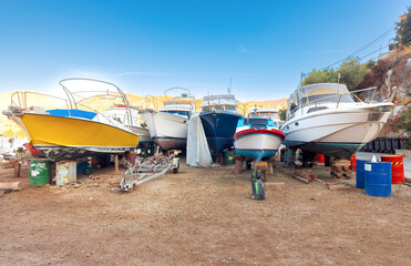 Wall Mural - Repaired fishing boats on carts on the shore of the bay in the village of Symi.