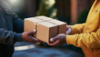 A close-up of a delivery man's hands delivering a package and a customer's hands picking it up at the front door.