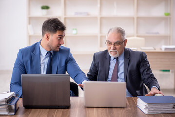 Wall Mural - Two male employees working in the office