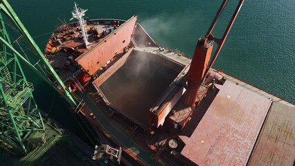 Wall Mural - Aerial view of big cargo ship bulk carrier is loaded with grain of wheat in port at sunset