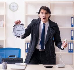 Wall Mural - Young male employee in the office in time management concept