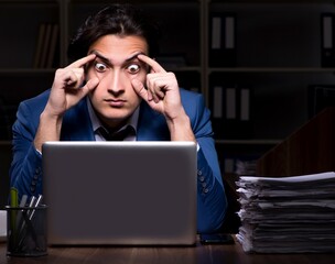 Poster - Young male employee working night in the office