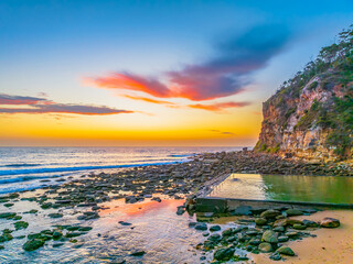 Wall Mural - Sunrise at the seashore with colour in the clouds