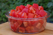 Transparent glass bowl with chopped tomatoes.