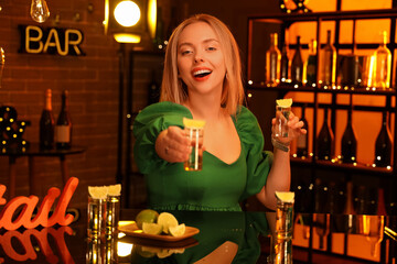 Wall Mural - Young woman with tequila shots in bar at night