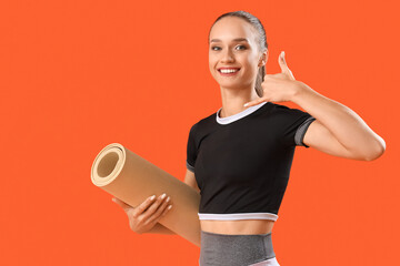 Female trainer with fitness mat showing 