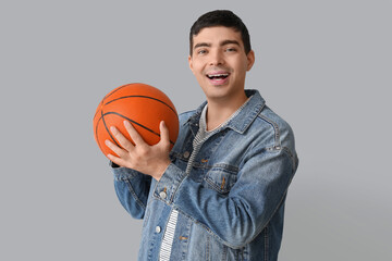 Wall Mural - Happy young man with ball on light background