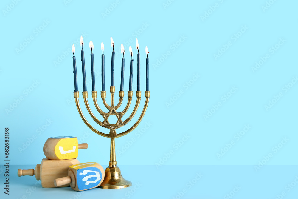 Menorah with dreidels on blue background. Hanukkah celebration