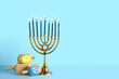 Menorah with dreidels on blue background. Hanukkah celebration