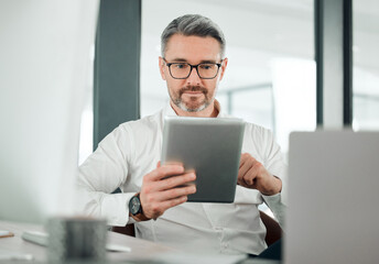 Fototapete - Mature man, business and tablet at desk in office for planning research, online report or scroll information. Entrepreneur, digital news and software update for social network, reading review and app