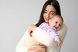 © Pixel-Shot - Happy mother with her little baby on light background