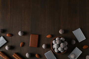 Wall Mural - Chocolate balls in a wooden bowl with chocolate bars and almonds