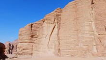 Massive Sandstone Blocks Create Sheer Cliffs Against Bright Blue Sky, Wadi Rum