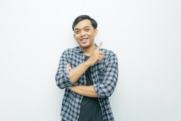 Portrait Indonesian Asian young man smiling with index finger pointing up. Casual concept isolated white background