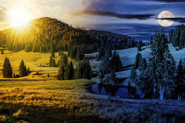 Wall Mural - mountain landscape with sun and moon at twilight in autumn season. small pond in the valley at the f