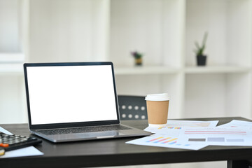 Wall Mural - Laptop computer with white screen, document and office supplies on black wooden work desk