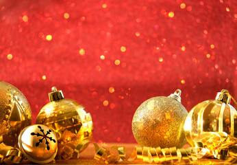 Wall Mural - Golden Christmas balls, decorations close up on abstract red shiny glittering background. festive winter season. New year and Christmas holidays concept. copy space. template for design