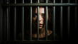 © TRAVELARIUM - Sorrowful female inmate sad behind bars desperately asking to released from custody symbolizing quest for fairness, treacherous criminal woman in prison embodies societal threat