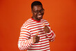 African-American man with thumbs up approving something on orange background