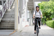 © Nassorn - Smart businesswoman ride bicycle in downtown. Environmentalist commuting by cycling reduce carbon footprint global warming. Bike to work eco friendly alternative transportation green energy vehicle