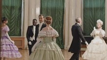 Full Length Shot Of Multiracial People In Charming Victorian Style Dresses Dancing With Each Other At Glamorous Debutante Ball