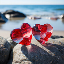 Two Beautiful Red Glass Hearts On Gray Stones Against A Blue Sea Background