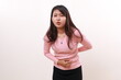 © ArvStd - Young asian girl feeling pain on her belly. Stomachache concept. Isolated on white background