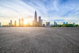 Asphalt road and urban skyline with modern buildings at sunset in Shenzhen, Guangdong Province, China.