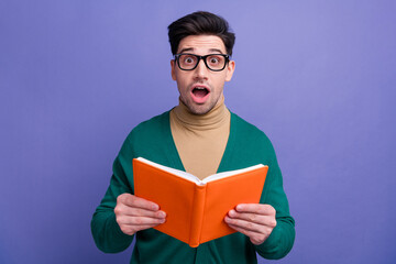 Wall Mural - Photo of astonished impressed man wear trendy clothes hold book read novel interesting detective plot isolated on purple color background