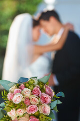 Poster - Flower, bouquet and couple with hug at wedding for love, smile and commitment at garden reception. Roses, happy woman and man embrace at marriage celebration event, partnership or future together