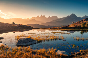 Wall Mural - Sunrise shines over Lac Guichard with Arves massif and lake reflection in autumn at Aiguilles d Arves, French Alps, France