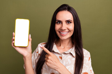 Sticker - Photo of young cheerful lady wearing peach shirt directing finger new phone app secure data messenger isolated on khaki color background