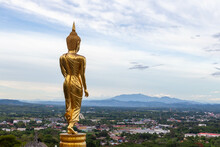 Standing Golden Buddha Statue Overlooking Nan Town, Mountains And Valley In Nan, North Thailand. Beautiful View From Wat Khao Noi.