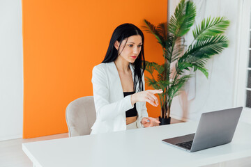 Businesswoman with hand on chin using smart phone at coffee shop