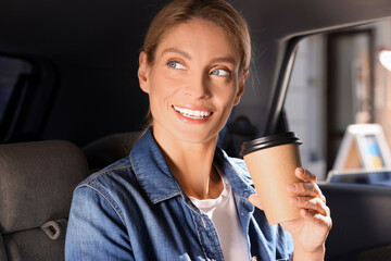 Wall Mural - Coffee to go. Happy woman with paper cup of drink in car