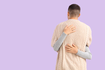 Sticker - Young couple hugging on lilac background