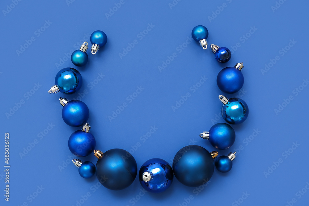 Composition with frame made of Christmas balls on blue background