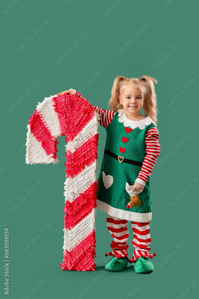 Cute little elf with candy cane pinata on green background