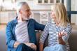 © brizmaker - Mature man and woman talking and relaxing on couch in dining room