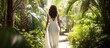 Woman walking in tropical garden in white dress. Brunette with long black hair