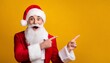 Santa Claus standing in front of yellow colored background and pointing towards blank space next to him. Winter seasonal sales and party invitations. christmas adverts discount point finger copyspace