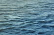 The raging waters of the river. Top view background texture of the raging elements. White foam on blue waving water in evening.