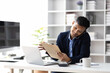 © Kainnika - Businessman in office using smartphone to send message and call to someone on mobile phone.