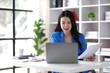 © Kainnika - Attractive asian businesswoman secretary working with laptop and paperwork in office.