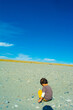 © ANGLECAT - 中田島砂丘の砂利で遊ぶ子どもの後ろ姿と青空
