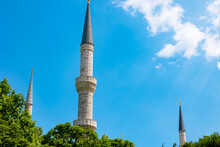 Islamic Background Photo. Minarets Of A Mosque Isolated On Blue Sky Background
