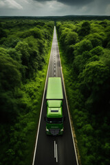 a green truck drives on a straight line road between forest