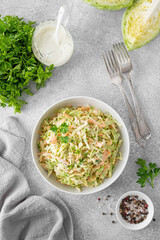 Wall Mural - Traditional cole slaw salad in a bowl on a gray concrete background. Salad with cabbage, carrot and mayonnaise sauce. Selective focus, copy space.