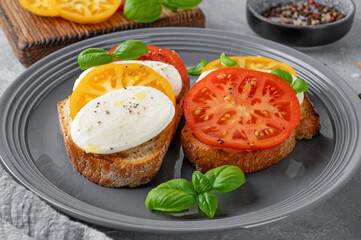 Wall Mural - Sandwich caprese with rye bread, tomatoes, mozzarella and fresh basil on a gray plate on a concrete background. Healthy food.