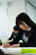 © Paylessimages - 教室で勉強している制服の高校生